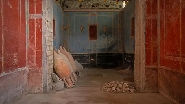 Small blue room used for prayer. A pile of oyster shells lie on the floor on the right