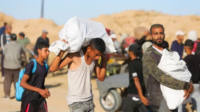 Мужчина и подросток с мешками с продовольствием