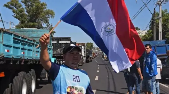 Homem carrega bandeira do país