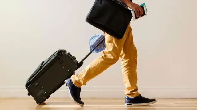 লাগেজ হাতে একজন হেঁটে যাচ্ছে