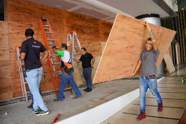 Trabajadores colocan protección contra huracanes en Cancún