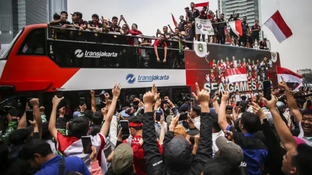Pesepak bola Timnas Indonesia U-22 berada di atas bus dalam pawai emas saat melintas di Bundaran HI, Jakarta, Jumat (19/5/2023).