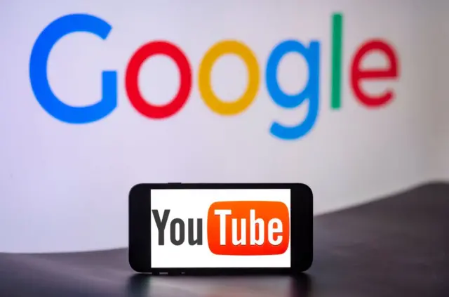 Un móvil con el logo de YouTube frente al logo de Google