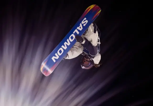 空中の村瀬が右手でボードをつかんでいる