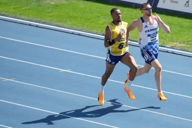 Timothee Adolphe es un atleta francés ciego que está corriendo junto a un corredor guía sobre una pista azul