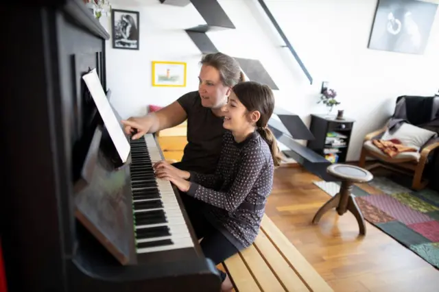 Criança aprendendo a tocar piano