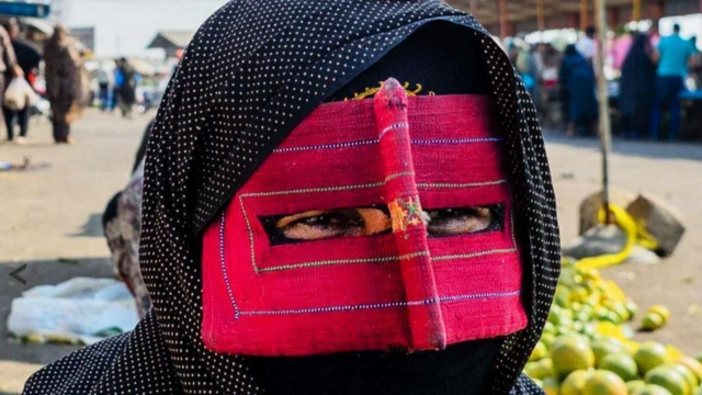 मास्क पहनी हुइ एक ईरानी बंदारी महिला