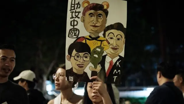 A demonstrator holds a sign as they occupy a road in protest against plans by the main opposition Kuomintang (KMT) and the Taiwan People's Party (TPP) to expand the parliamentary powers during the vote for the Parliament reform bill, outside the Parliament in Taipei on May 24, 2024. Tens of thousands of Taiwanese protesters rallied day and night outside parliament on May 24, as lawmakers inside traded insults, blows and theatrics over a series of bills to expand the legislature's power. (Photo by Yasuyoshi CHIBA / AFP) (Photo by YASUYOSHI CHIBA/AFP via Getty Images)