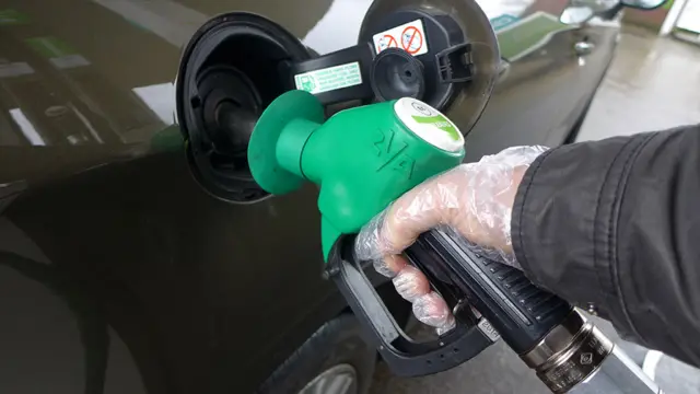 Hand filling a car with petrol