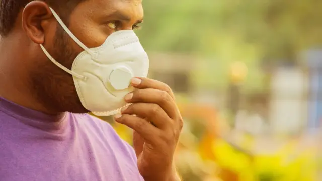 Un hombre con una mascarilla para protegerse de la contaminación.