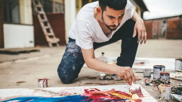 Un hombre pintando en el suelo