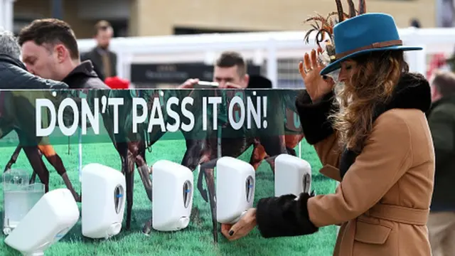 یکی از تماشاچیان مسابقه اسبدوانی در چلنتنهام انگلستان دستهایش را ضدعفونی میکند.