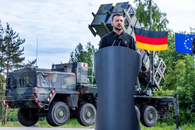 Volodimir Zelenskiy bir askeri eğitim alanında konuşuyor, arkada Patriot bataryası var.