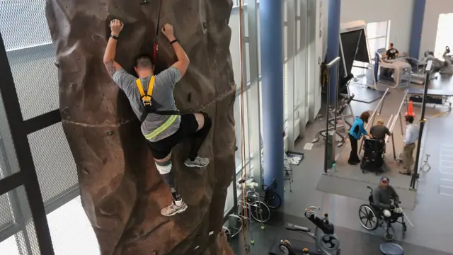 Veterano de guerra escalando en un rocódromo