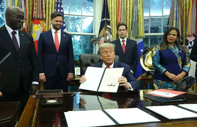 Le président américain Donald Trump signe une lettre de félicitations lors de sa rencontre avec le ministre des Affaires étrangères et de la Coopération du Rwanda, Olivier Nduhungirehe, et la ministre des Affaires étrangères de la République démocratique du Congo, Thérèse Kayikwamba Wagner, dans le bureau ovale de la Maison Blanche, le 27 juin 2025.