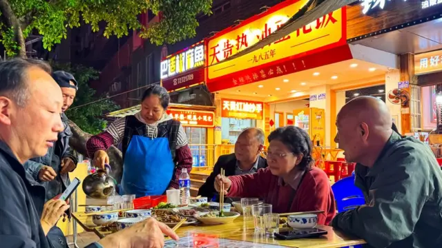 一些中老年市民在户外吃饭。