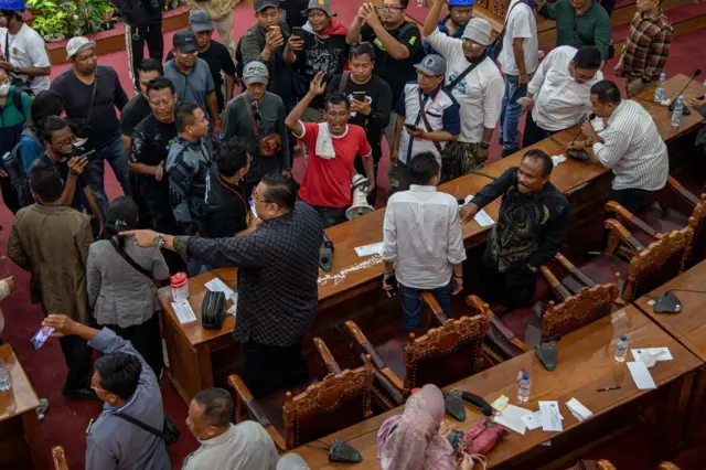 orang sedang berdebat dalam ruangan DPRD.