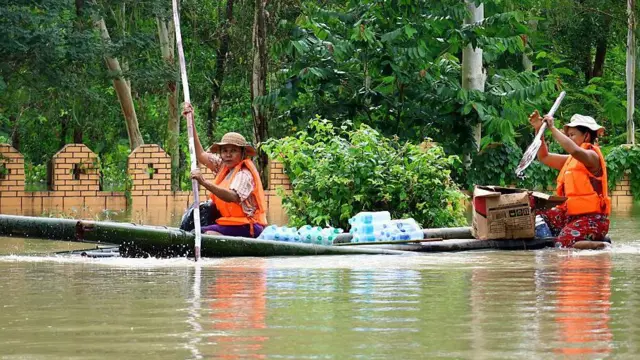 ဩဂုတ် ၃ ရက်တုန်းက ရေလွှမ်းနေတဲ့ လေးမျက်နှာမှာ ဝါးဖောင်ကိုသုံးပြီး သောက်ရေသန့်တွေ သယ်နေကြတဲ့ လေးမျက်နှာဒေသခံတချို့
