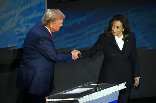 Donald Trump y Kamala Harris estrechan las manos antes del debate entre ambos. 