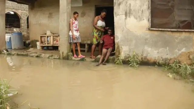 Omi kun de bebe abawọle ile yii, awọn ọmọbinrin mẹta wa nibẹ, ọkan ninu wọn ki ẹsẹ bọ omi naa.