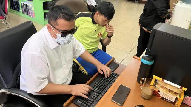 Aris mengajarkan cara menyunting audio kepada muridnya di SLB Pembina Tingkat Nasional, Jakarta.