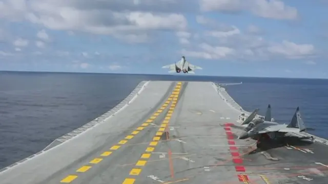 విమాన వాహక యుద్ధనౌకపై నుంచి ఎగురుతున్న యుద్ధ విమానం