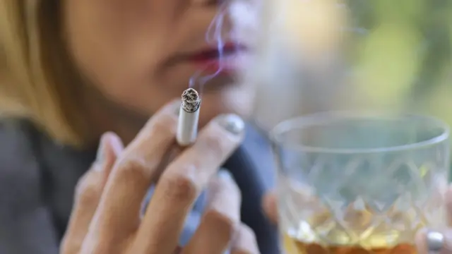 Mujer fumando y bebiendo