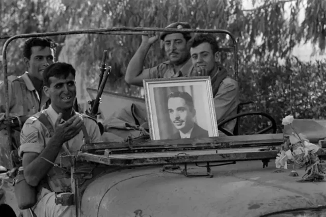 چند سرباز اردنی در یک جیپ با عکسی از شاه حسین