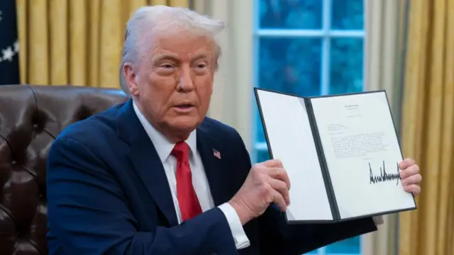  एग्जीक्यूटिव ऑर्डर पर हस्ताक्षर करने के बाद उसे दिखाते हुए राष्ट्रपति डोनाल्ड ट्रंप 