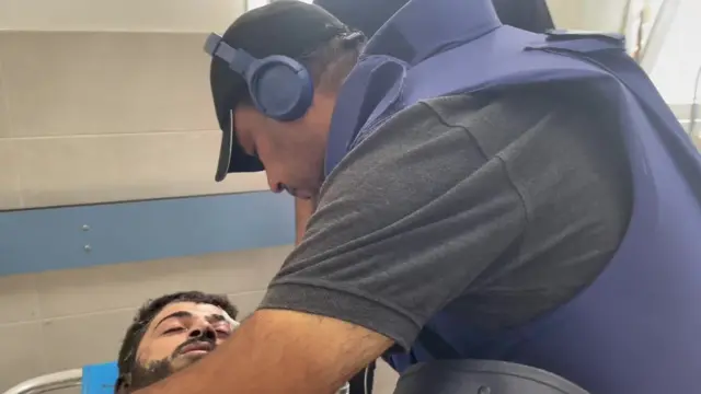 Mahmoud al-Ajrami consolant un homme.