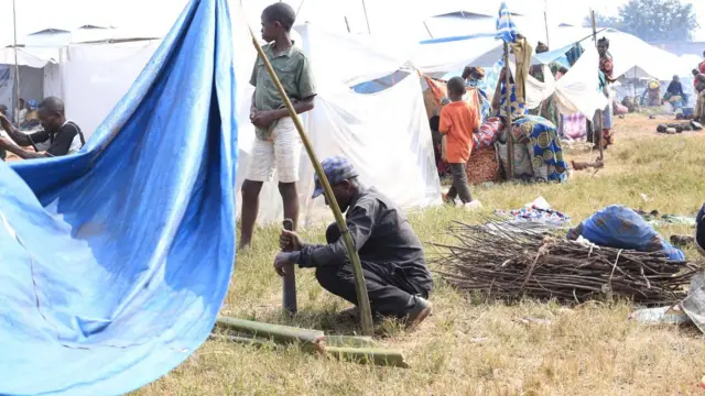 Umugabo ariko arubaka ihema yo kubamwo ku kibuga c'umupira ca Rugombo mu ntara ya Cibitoke