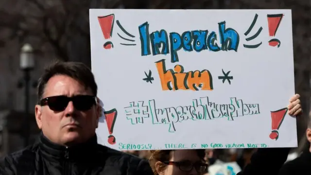 ટ્મ્પના ઇમ્પિચમેન્ટની માગણી સાથે એક પ્રદર્શનકારી