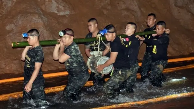 عمال يحاولون تفريغ المياه من الكهف