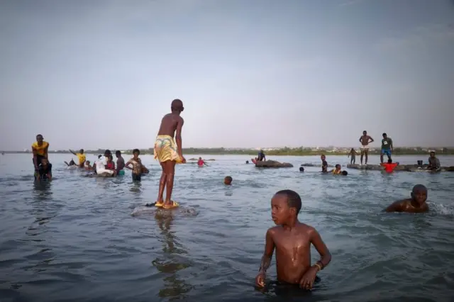 People in Mali bathe in the Niger River before sunset.