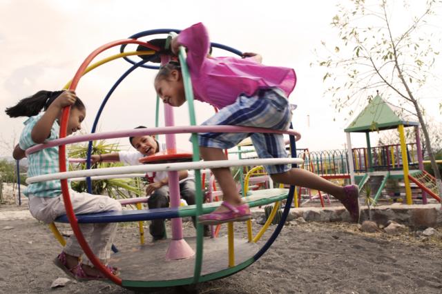 Crianças brincando em brinquedo giratório no parque