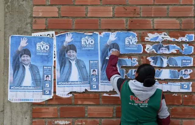 Seorang warga mencabut poster Morales setelah ia mengumumkan diri mundur dari posisi presiden