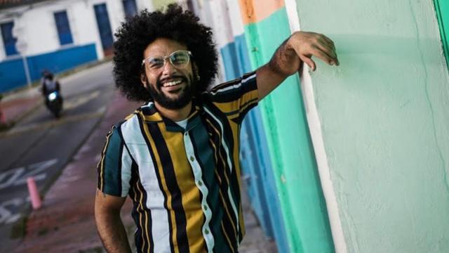 Oscar Eduardo López sorrindo na rua, encostado na paredejogos de aposta pela internetuma casa com pose relaxada