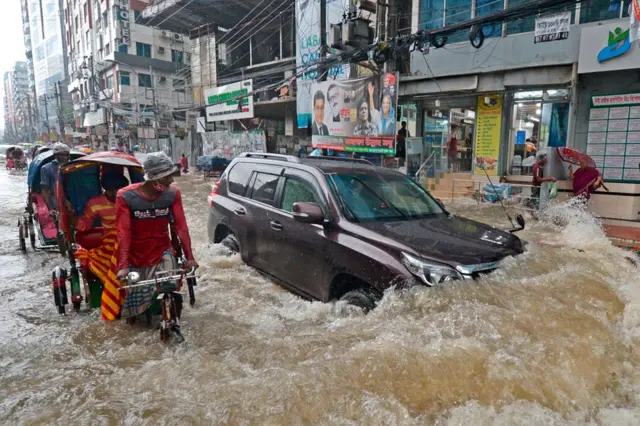 Les banlieusards se frayent un chemin dans une rue inondée