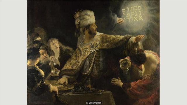 在伦勃朗的作品《伯沙撒的盛宴》中，巴比伦国王用一只抢夺来的圣杯饮酒，亵渎了上帝，一只圣神的手写下了警告。