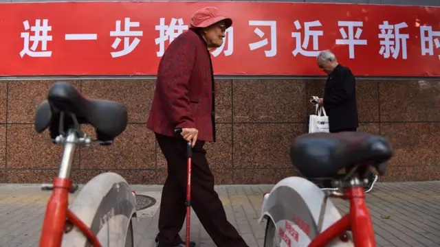 北京市民走在宣传习思想的标语旁。