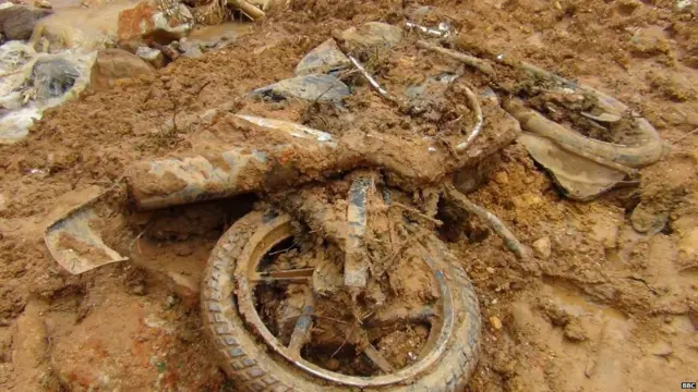 රත්නපුර දිස්ත්‍රික්කයේ පස් කඳුවලට යට වූ යතුරු පැදියක්