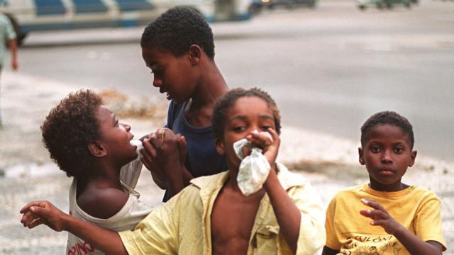 Niños aspirando pegamento en una calle en Brasil