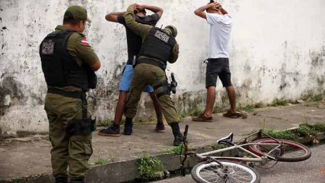 Policiais militares revistam homens nas ruasracha cuca jogosBelém, Pará