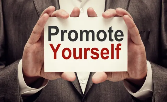 Hombre con cartel que dice: "promociónate".