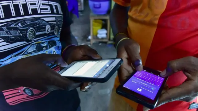 شخصان يمسكان بهاتفيهما المحمول وينهمكان في الكتابة عليهما