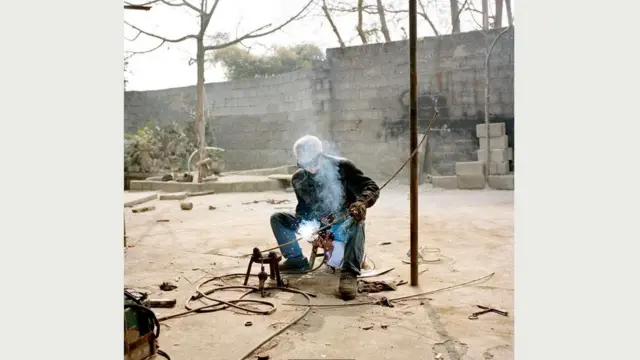 После того, как кто-то украл у него планер и двигатель, чтобы сдать в утиль, Цао Чжэншу (на снимке - за работой) поставил в сарае кровать и ночует там, присматривая за своим самолетом