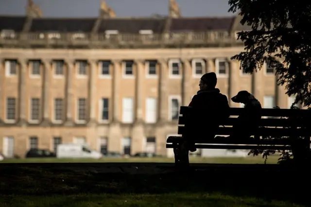 Bir adam ve köpeği bankta oturuyor