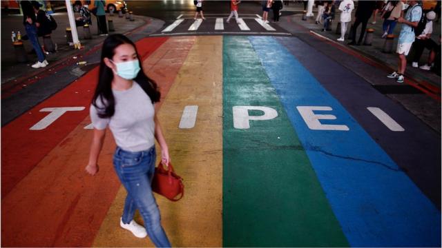 A pedestrian wearing a mask crosses the street in Taipei, Taiwan, 11 May 2021. Taiwan Health and Welfare Minister Chen Shih-chung announced during a press conference on 11 May, that Taiwan has entered the community transmission stage of COVID-19 following the emergence of six domestic cases of the disease that have unknown sources of infectio