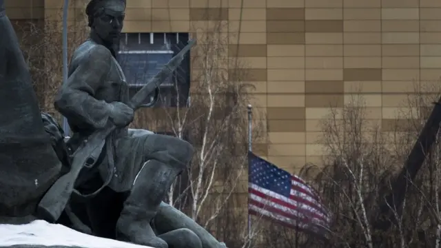Памятник революции 1905 года на фоне флага посольста США в Москве