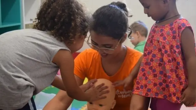 Professora e crianças do projeto-piloto Cantinho do Brincar